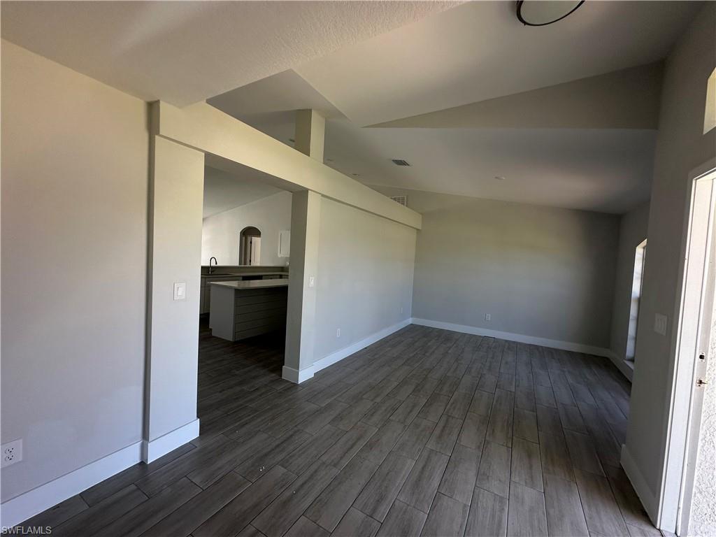 Image 3: Spare room with wood finished floors and lofted ceiling