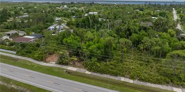 Image 4: Aerial view showcasing mature landscaping with lush tree canopy, manicured grounds, and established residential development