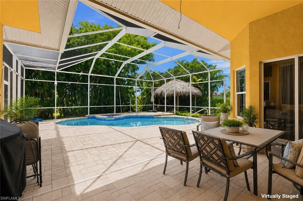 Image 4: Screened lanai featuring a swimming pool and built-in spa