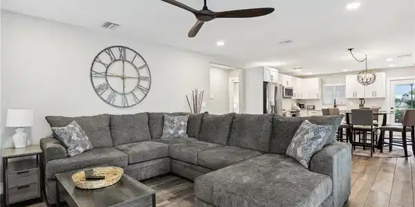 Image 4: Living room featuring wood-type flooring and ceiling fan with notable chandelier