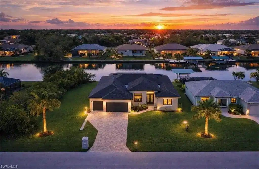 Image 1: View of front of property with a water view, a residential view, decorative driveway, an attached garage, and a lawn (Rendered photo)