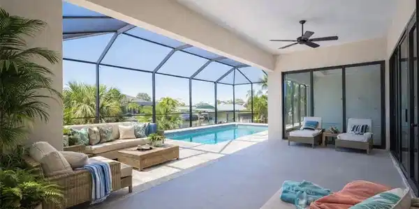 Image 2: Outdoor pool featuring an outdoor hangout area, a sunroom, glass enclosure, and a patio (Rendered photo)