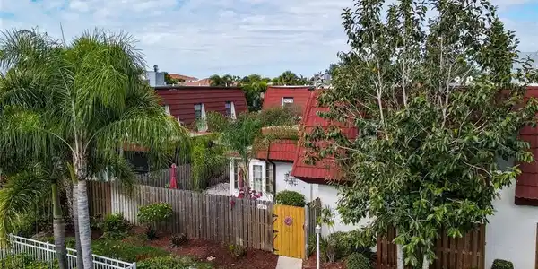 Image 3: Aerial View of Front of Townhome shows Pool Area to left of the townhome entrance gate. Includes 2 assigned parking spaces in front of the gate.