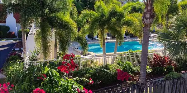 Image 4: Private Balcony off the primary bedroom. Overlooks the private courtyard and views of the Pool that is just steps away from your townhome.