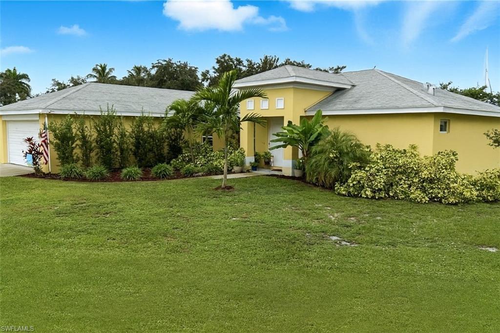 Image 1: Single story home with a front lawn, stucco siding, and a garage