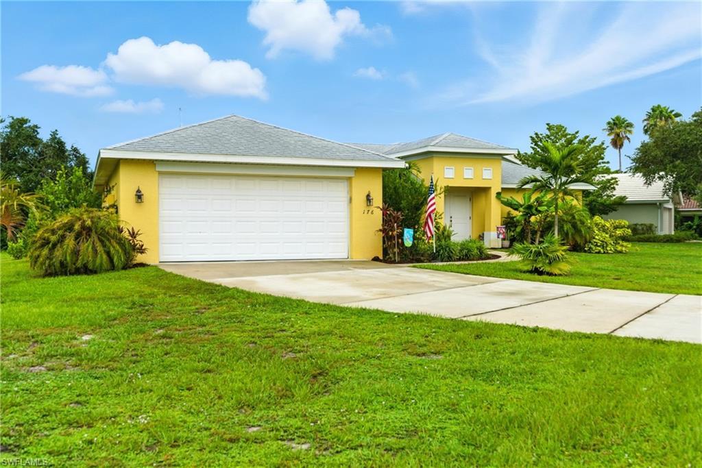 Image 2: View of front of house featuring stucco siding, concrete driveway, a front lawn, a shingled roof, and a garage