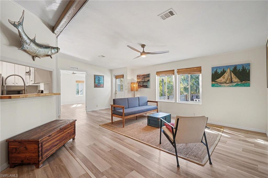 Image 2: Living area with light wood-type flooring and ceiling fan