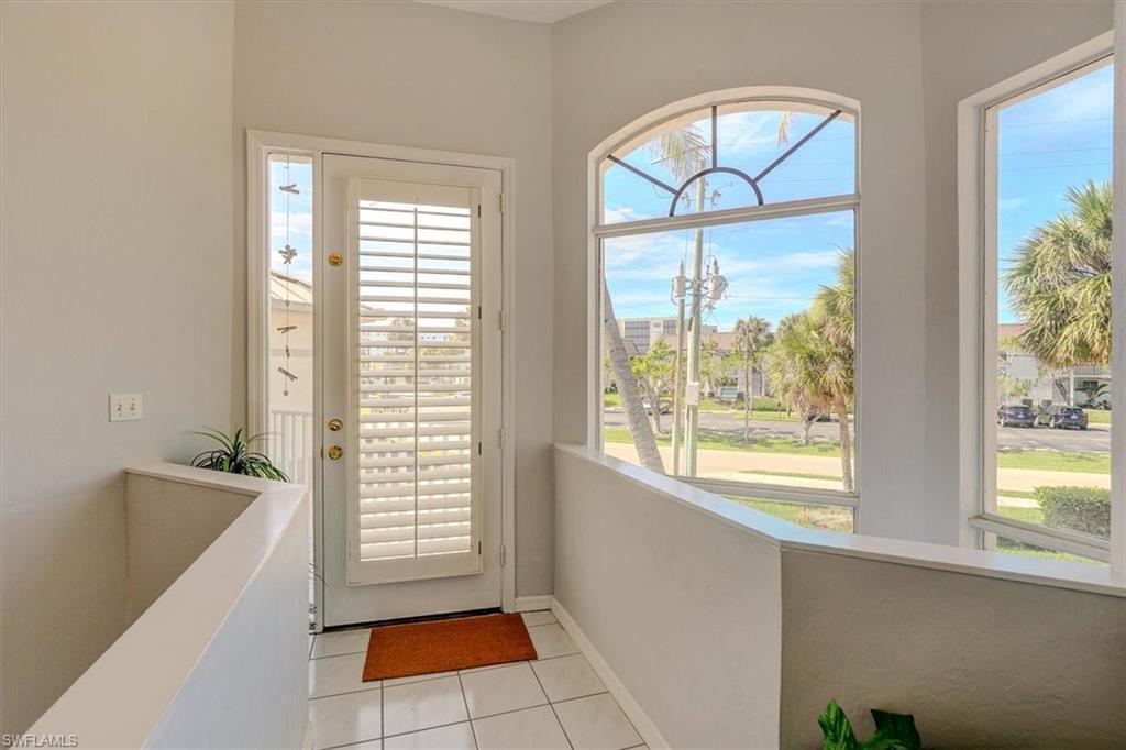 Image 3: Doorway to outside with light tile patterned flooring and baseboards