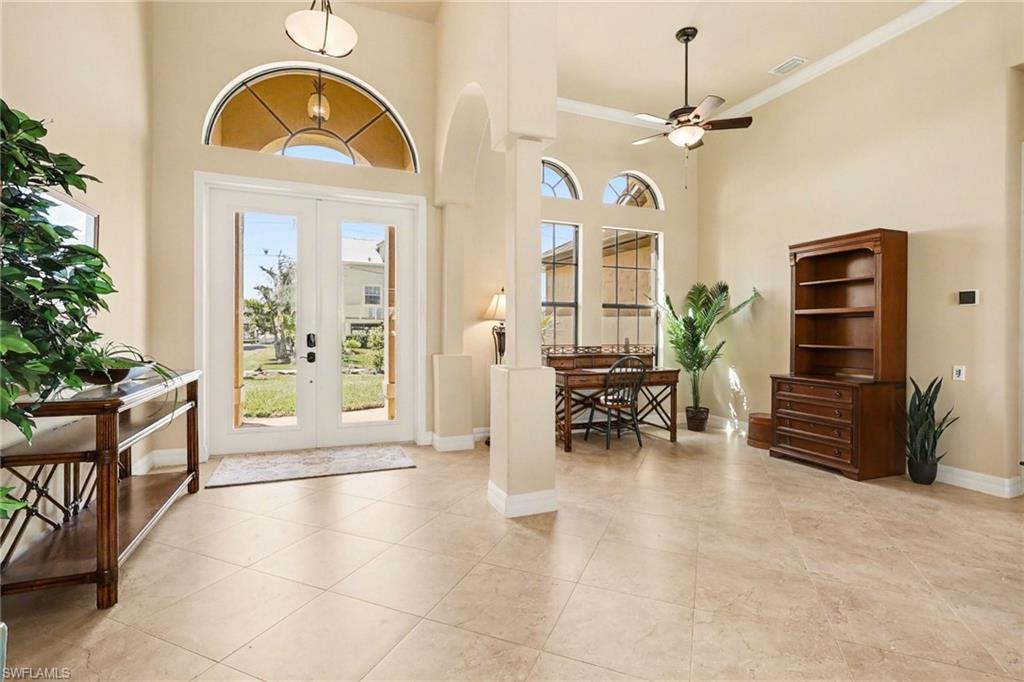 Image 3: Entry way featuring a high ceiling, french doors, ceiling fan, and crown molding.