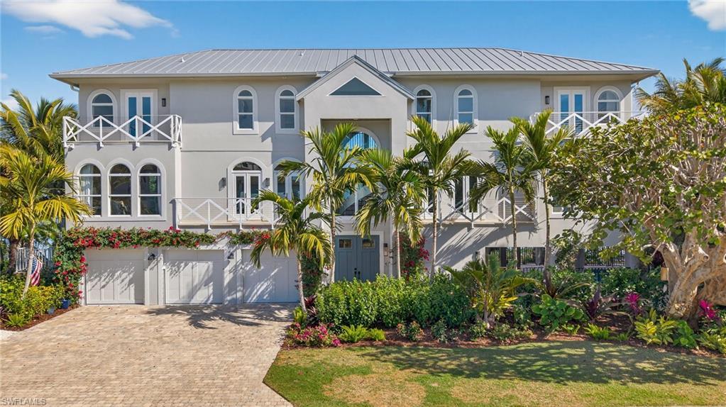 Image 2: View of front of property with a metal roof, stucco siding, decorative driveway, and a garage