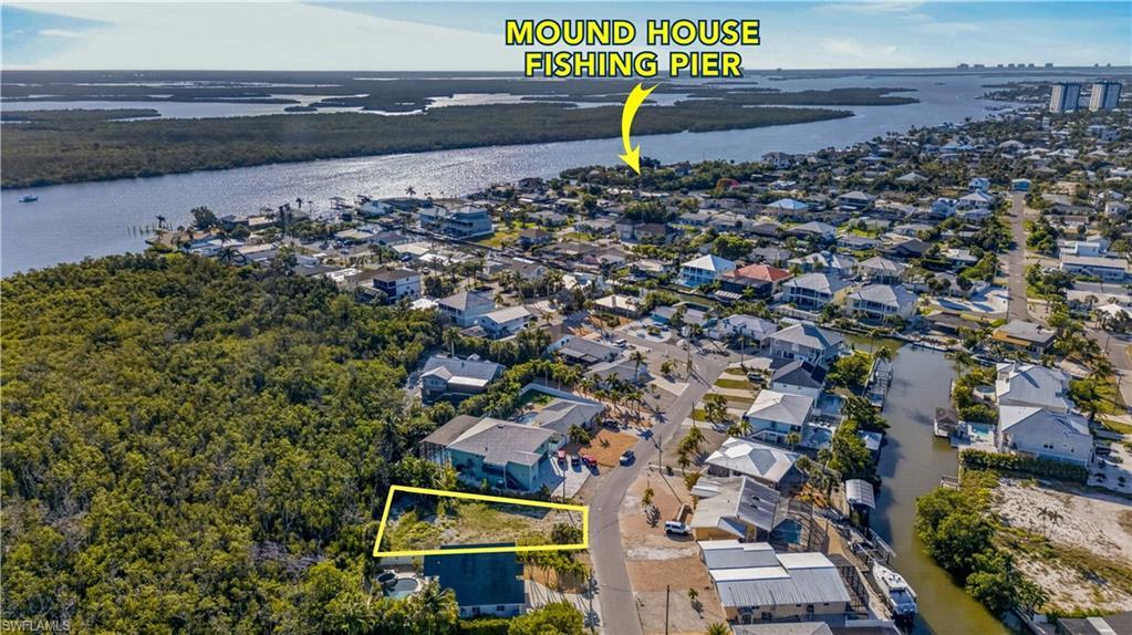 Image 3: Cleared lot with surrounding residential properties, featuring paved road frontage - Virtually Edited Image