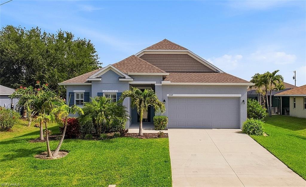 Image 2: Contemporary single-story residence featuring a two-car garage, concrete driveway, and a low-sloped shingle roof