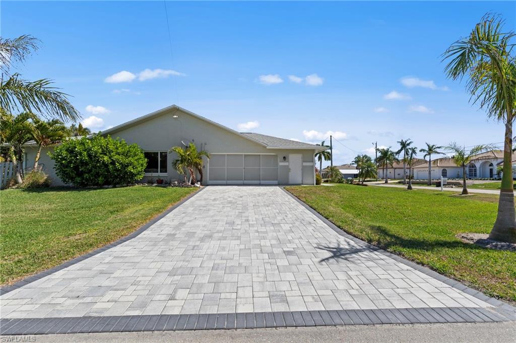 Image 2: Ranch-style house with stucco siding, decorative driveway, a front lawn, and a garage