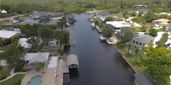 Image 4: Aerial View from the Peace River looking down the canal. 25301 Harborview Rd. is in the background on the right of the main canal