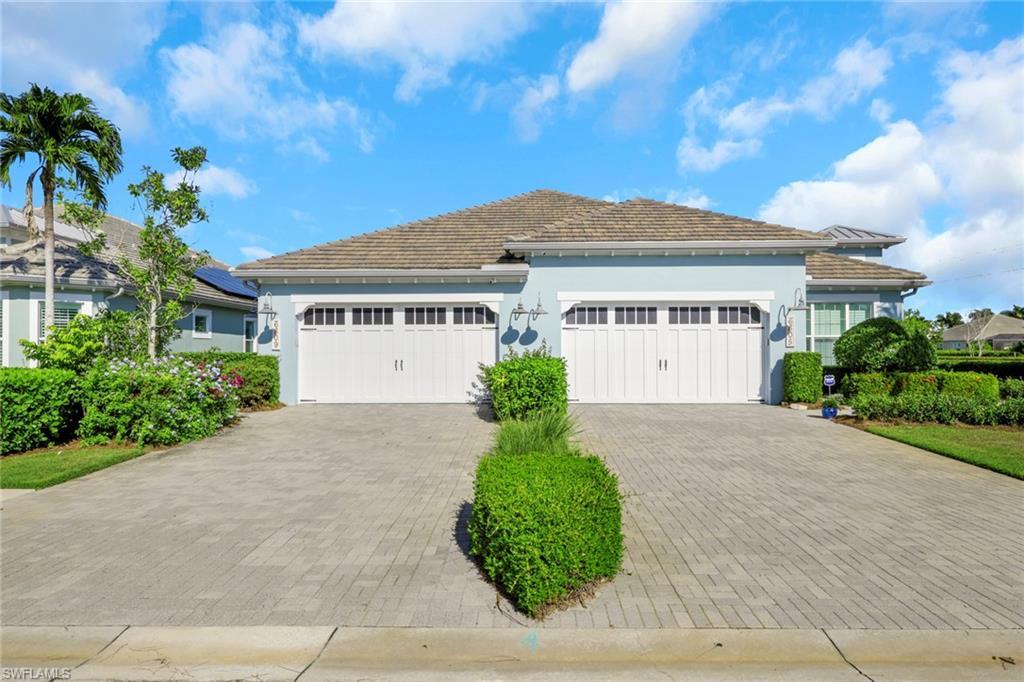 Image 3: View of front of property featuring stucco siding, decorative driveway, and a garage