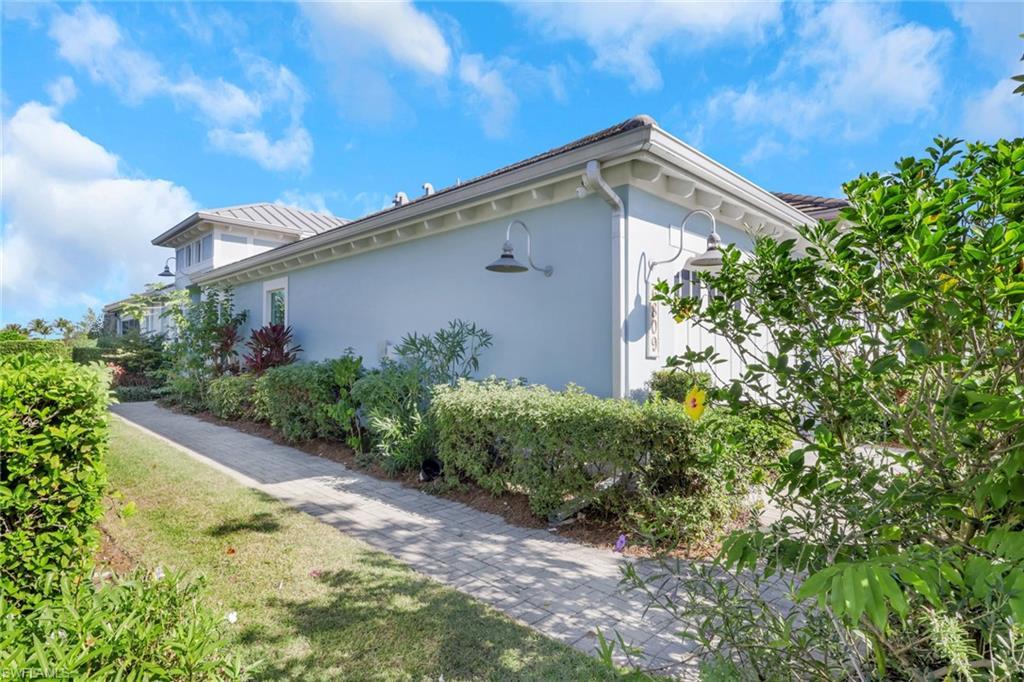 Image 4: View of property exterior with stucco siding and a yard
