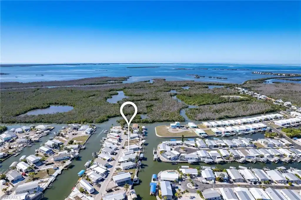 Image 1: Aerial overview of property's location with a nearby body of water