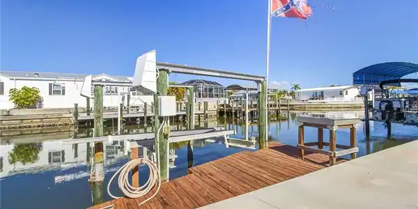 Image 2: Dock area featuring boat lift and a water view