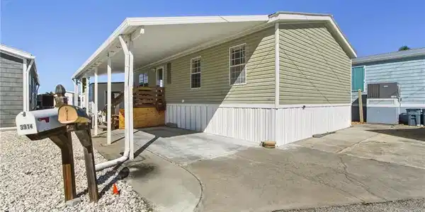 Image 4: View of home's exterior with a carport and driveway