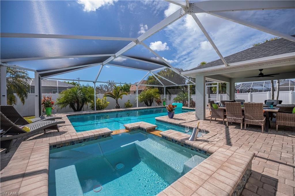 Image 3: Integrated pool / spa with a fenced backyard, a patio area, a sunroom, glass enclosure, and outdoor dining area