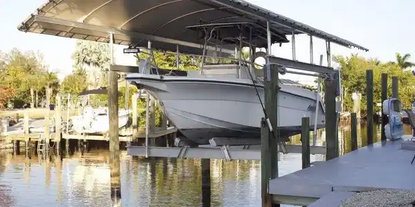 Image 2: Dock featuring boat lift and a water view