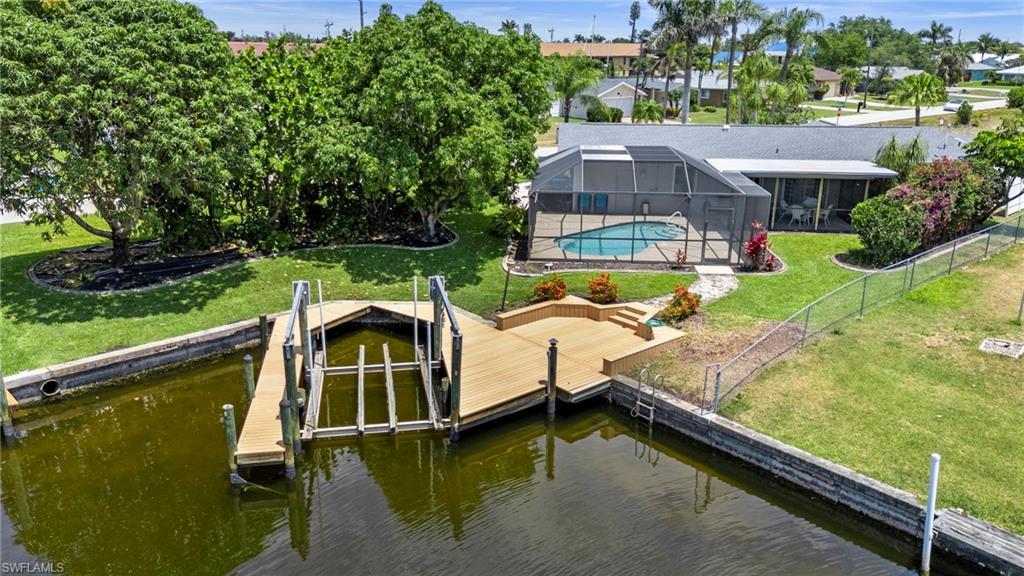 Image 1: Dock with glass enclosure, a yard, an outdoor pool, a water view, and boat lift