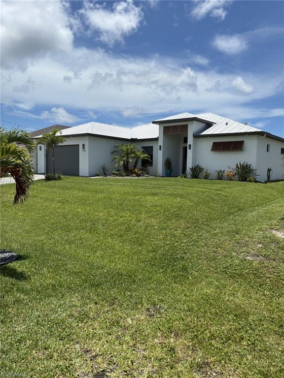 Image 1: Contemporary stucco exterior with a prominent entry portico, a white tile roof, and a large front lawn