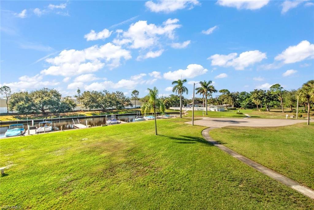 Image 4: View of property's community with a lawn, a dock, and a water view