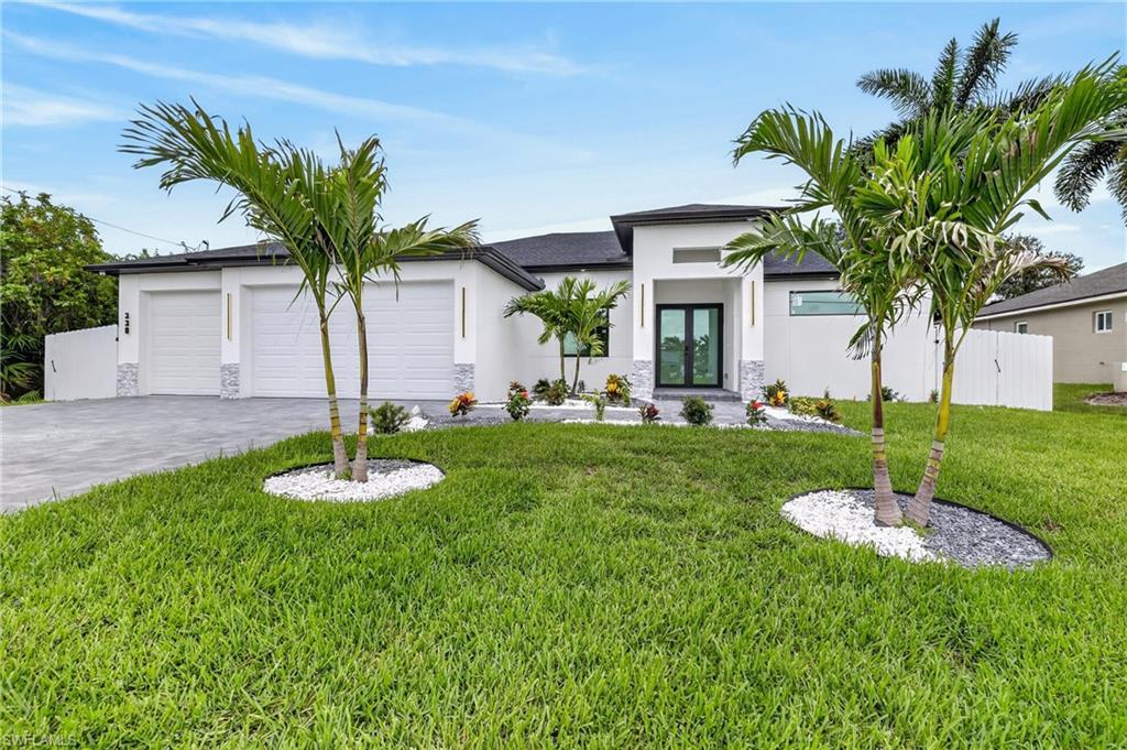 Image 1: Contemporary exterior featuring a white stucco finish, a double-door entry, a two-car garage, manicured landscaping, and twin palm trees