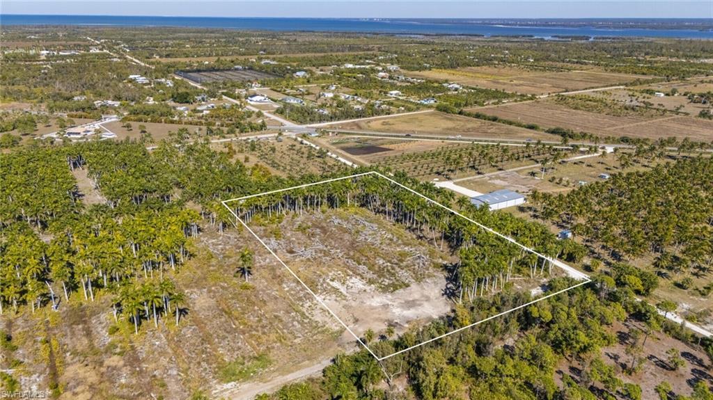 Image 2: View of rural area featuring property parcel outlined, rows of crops, and a large body of water