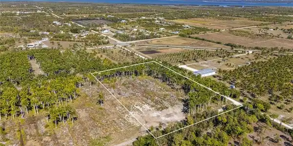 Image 2: View of rural area featuring property parcel outlined, rows of crops, and a large body of water