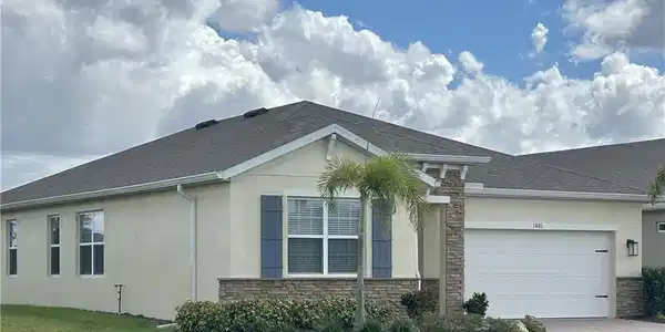 Image 4: View of front of home with stone siding, stucco siding, and a front yard