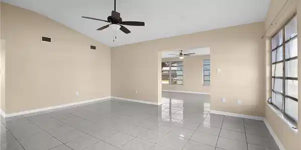 Image 3: Empty room featuring light tile patterned floors, vaulted ceiling, and ceiling fan