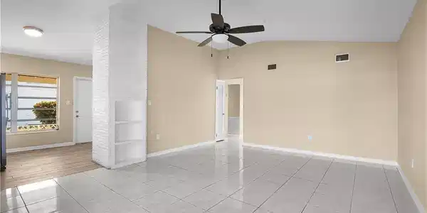 Image 4: Empty room featuring light tile patterned flooring, vaulted ceiling, and a ceiling fan