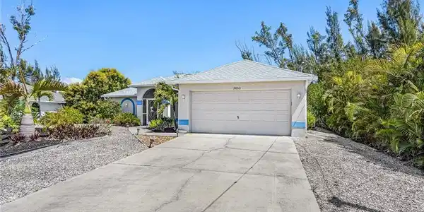 Image 3: View of front of home with concrete driveway, an attached garage, and stucco siding
