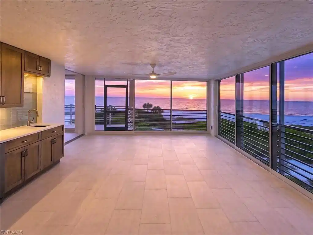 Image 1: The living area flows seemlessly into the enclosed lanai. The wet bar makes for easy entertaining