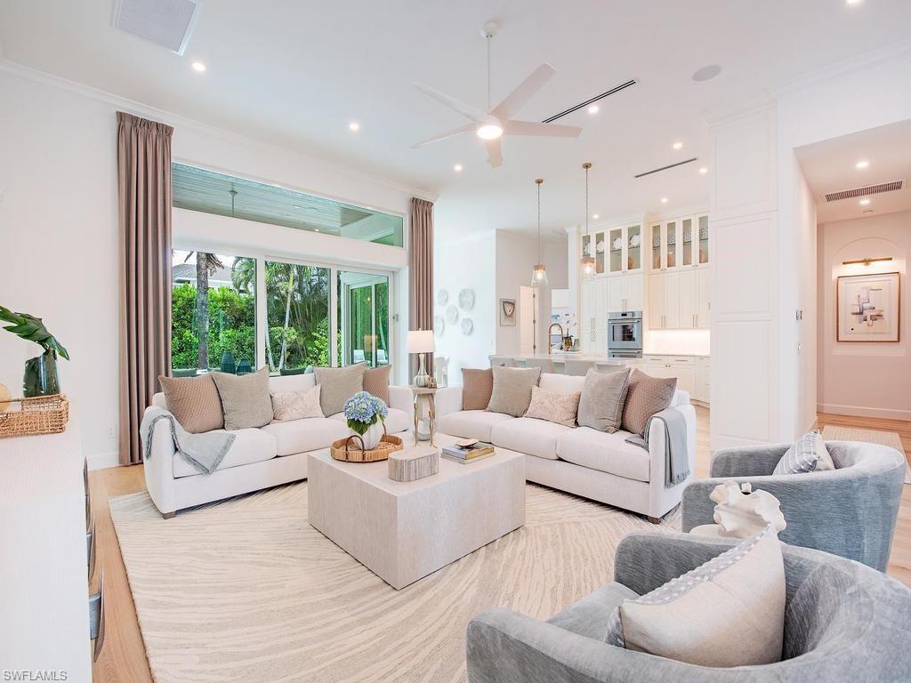 Image 2: Expansive living area featuring light wood-finish flooring, a large area rug, and recessed ceiling lighting
