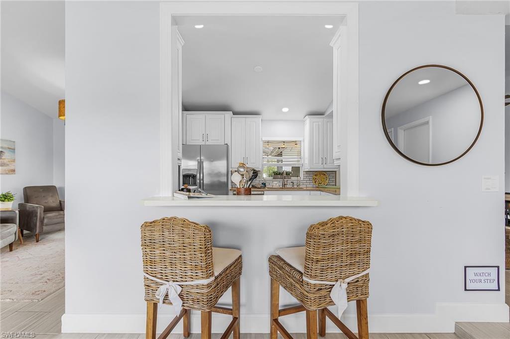 Image 3: Kitchen pass-through with a white countertop and recessed lighting