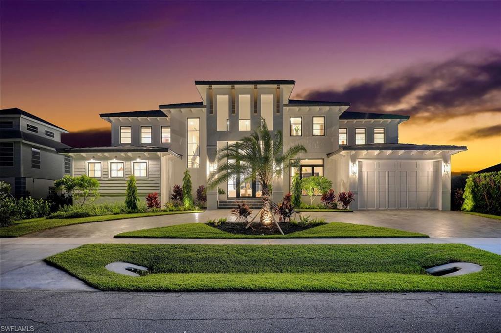 Image 1: Contemporary home with driveway, stucco siding, a garage, and a front lawn