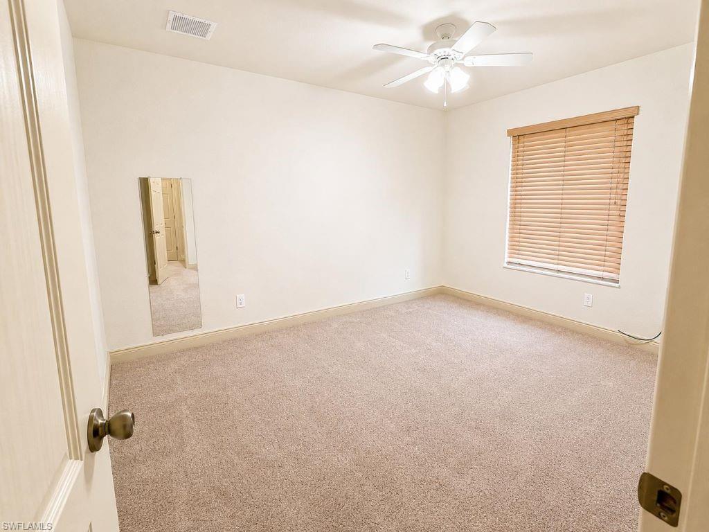Image 2: Carpeted room featuring a ceiling fan, a window with wood-finish blinds, and a mirrored wall panel