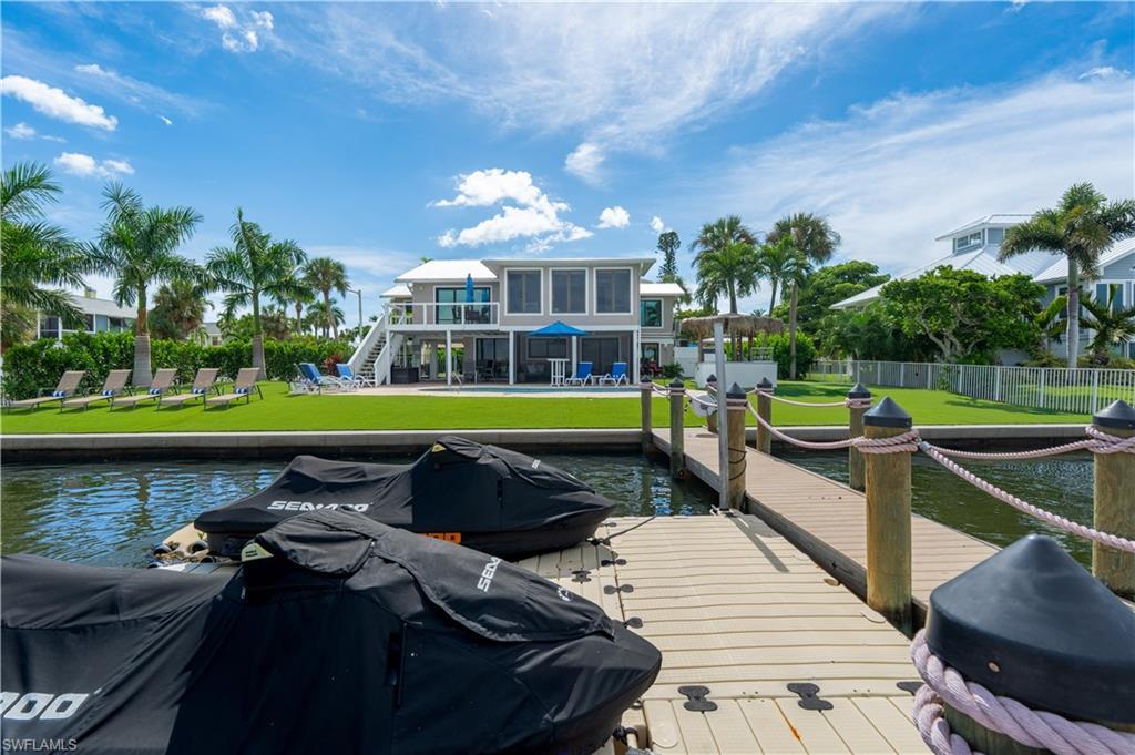 Image 1: Dock featuring stairs, a water view, a patio area, and a balcony - Virtually Edited Image