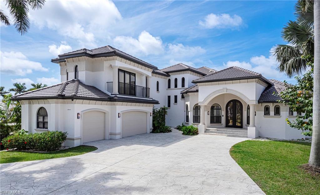 Image 2: Mediterranean / spanish house with stucco siding, driveway, a balcony, a front yard, and a tiled roof