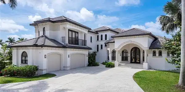 Image 2: Mediterranean / spanish house with stucco siding, driveway, a balcony, a front yard, and a tiled roof