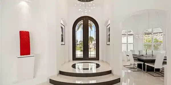 Image 3: Foyer entrance with french doors, arched walkways, a chandelier, and a high ceiling