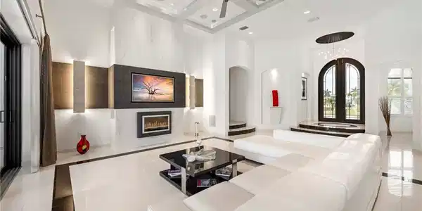 Image 4: Living area featuring a premium fireplace, coffered ceiling, ceiling fan, arched walkways, and inlaid floor details