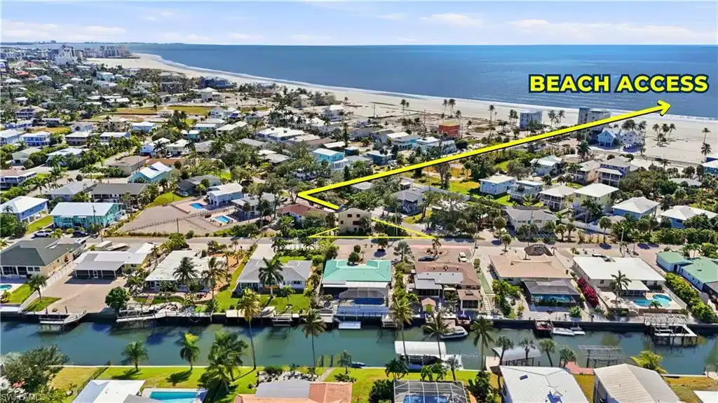 Image 1: BEACH ACCESS - Aerial perspective of suburban area with unending shoreline - Virtually Edited Image