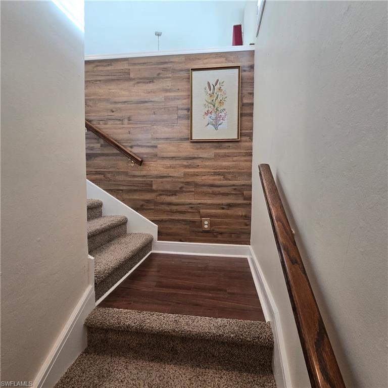 Image 2: Staircase featuring a textured wall and wood finished floors