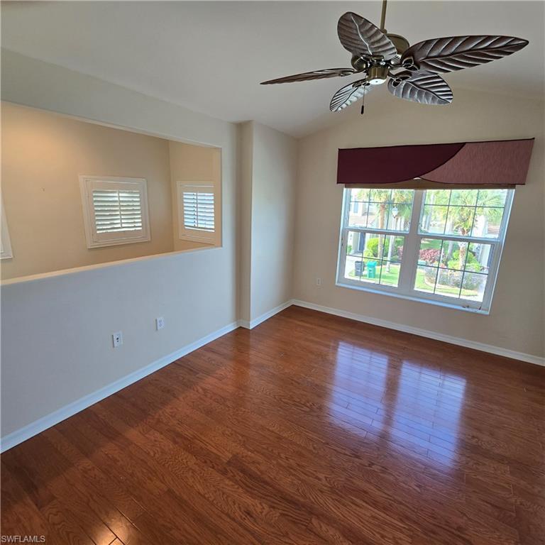 Image 3: Unfurnished room with vaulted ceiling, a ceiling fan, dark wood finished floors, and healthy amount of natural light
