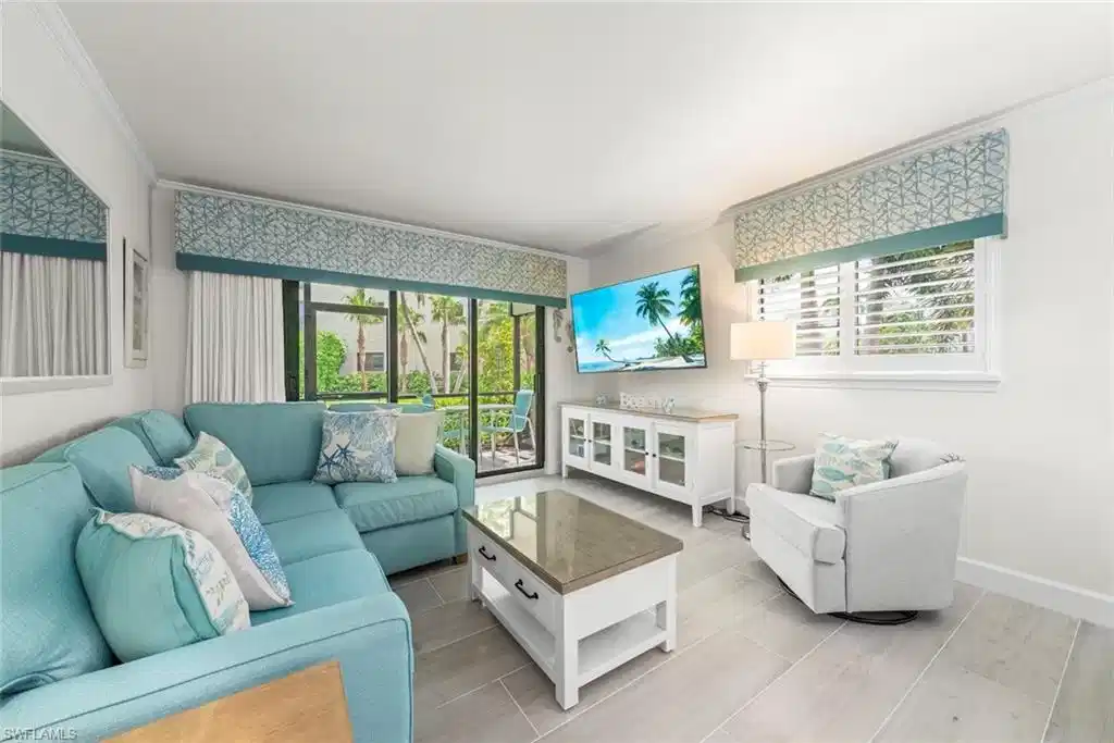 Image 1: Living area featuring wood-finish flooring, crown molding, and a large glass sliding door leading to an outdoor space