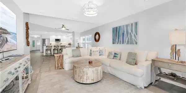 Image 2: Living room with a ceiling fan, lofted ceiling, and light tile patterned floors